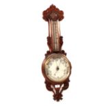 An aneroid barometer in carved oak case,