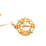 A 15ct gold circular brooch with seed pearls and turquoise stones