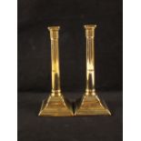 A pair of 18th Century brass candlesticks with part fluted cylindrical stems and beaded square