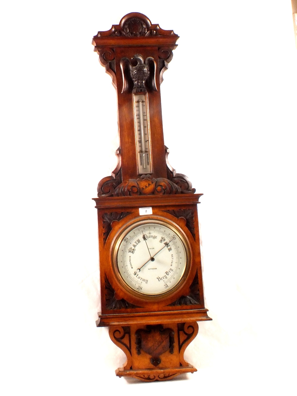 An aneroid barometer in carved oak case with eagle mount, signed J.