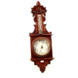 An aneroid barometer in heavily carved mahogany case