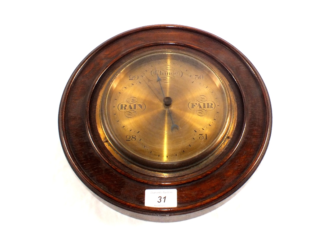 A circular oak brass dial barometer, signed Deacon & Sons,