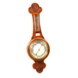 An aneroid barometer in carved oak case