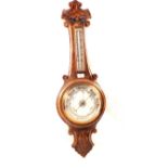 An aneroid barometer in carved oak case