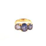 An 18ct gold three stone ring (the stones are possibly tanzanite),