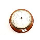 A circular carved mahogany cased barometer