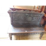 An 18th Century oak settle with stylised carved back