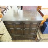 A dark Ercol two door fall front TV cabinet