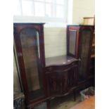 An Edwardian inlaid mahogany bow fronted display cabinet with central drawer and cupboard flanked