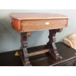 A mahogany two drawer work table on carved supports