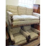 An oak framed three seat settee with Art Deco leaf inlays and cream upholstery and two matching