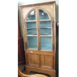 An oak two door display cabinet with painted interior and non matching pine base