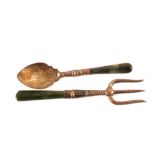 A silver spoon and fork with jade handles