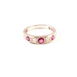A white metal fourteen stone diamond and ruby 3/4 hoop ring,