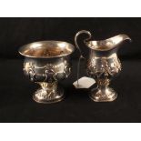An embossed silver cream jug and sucrier,