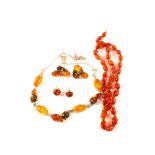 A matching silver and amber necklace and earrings plus a pair of amber earrings and a bead necklace