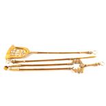 A heavy set of three brass fire irons with pierced shovel and decorative ring handles,