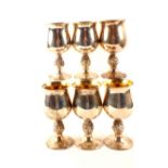 A set of six silver goblets with grape and vine decoration to stem, gilt interiors,