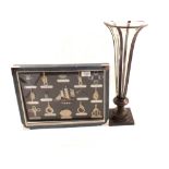 A case of nautical items plus a glass vase in metal stand