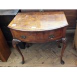 A reproduction walnut and cross banded bow front single drawer side table on cabriole legs