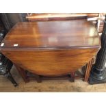 A mahogany oval gate leg table