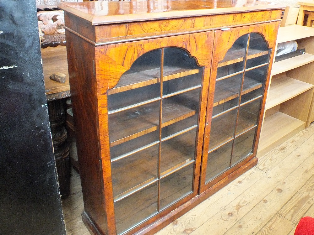 A Victorian flame mahogany and cross banded cabinet with two astragal glazed doors