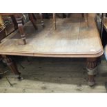 A Victorian oak extending dining table with two leaves on fluted legs