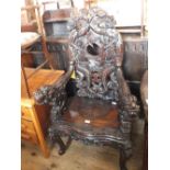 A Chinese hard wood elbow chair with all over dragon and bird carving