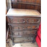 A Jacobean style oak three long drawer chest on barley twist supports