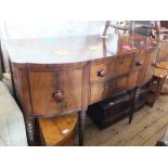 A Georgian mahogany bow front sideboard with cellarette on turned legs