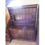 An oak shelf back dresser with three drawers and doors below