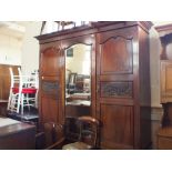 A Victorian carved mahogany single mirror door triple wardrobe on two drawer base