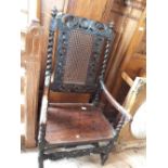 A Jacobean carved oak elbow chair with later replacement seat