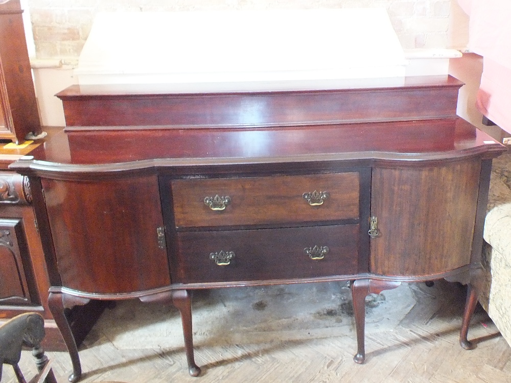 A mahogany sideboard with two central drawers flanked by cupboards on cabriole legs