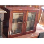 A mahogany glazed two door wall hanging cabinet