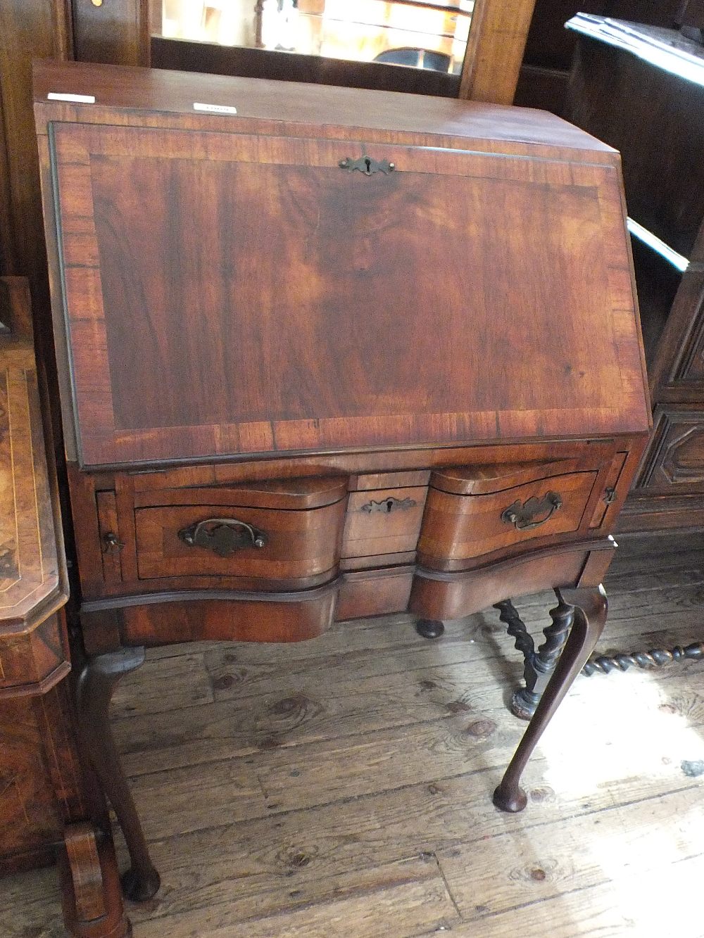 A mahogany and cross banded shape front bureau on cabriole legs