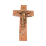 A brass crucifix on red variegated marble cross