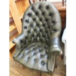 A green leather button back swivel armchair