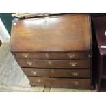 A Georgian oak bureau with four graduated drawers on bracket feet