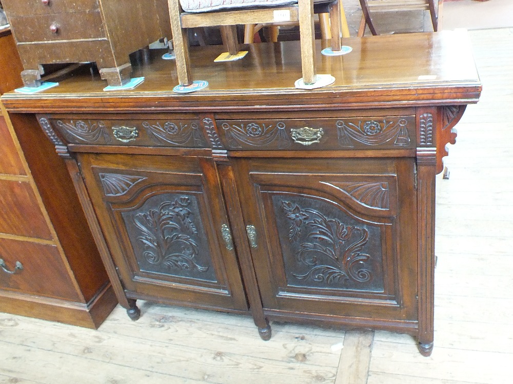 An Edwardian carved mahogany sideboard (back missing)