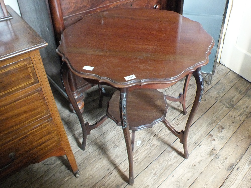 An Edwardian shaped topped two tier occasional table