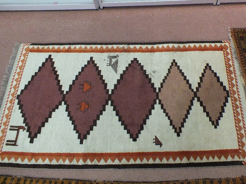 A wool rug with stylised animal and bird motifs
