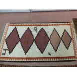 A wool rug with stylised animal and bird motifs