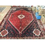 A Persian red ground carpet with central medallions,
