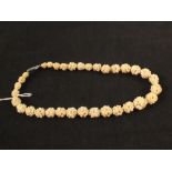 A carved ivory bead necklace