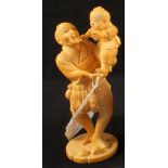 A Japanese ivory okimono of a man holding a child