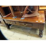 A large two drawer coffee table on turned legs