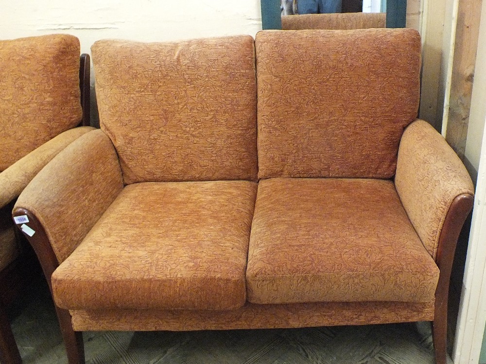 A modern wooden frame and terracotta upholstered three piece suite