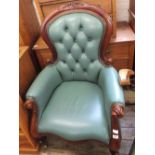 A mahogany button back armchair with green leather upholstery