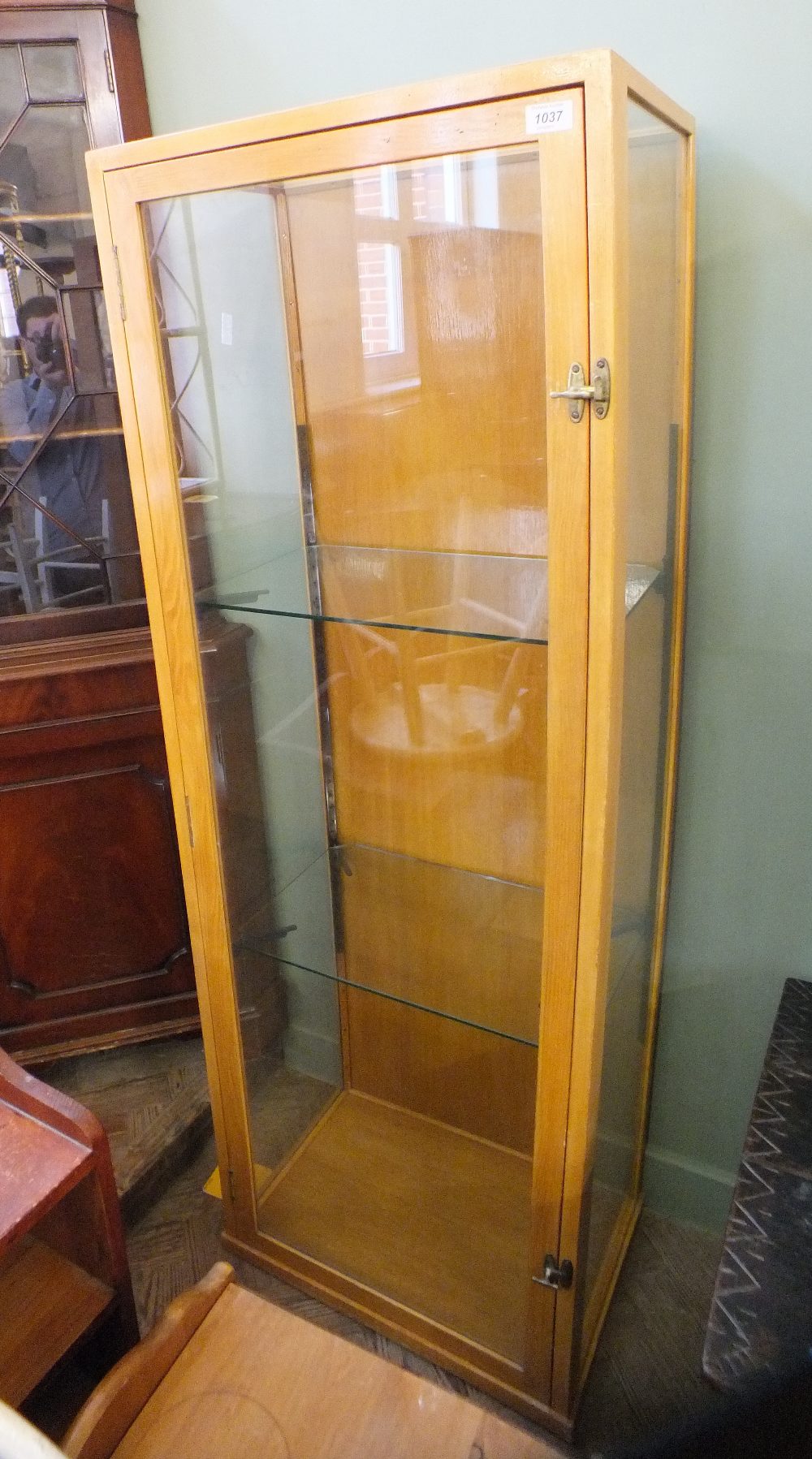 A light oak glazed single door shop display cabinet